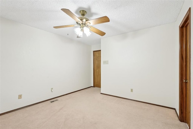 unfurnished room with visible vents, a ceiling fan, a textured ceiling, and light carpet