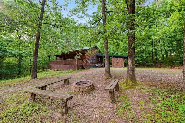 206 Orca Rd, Broken Bow, OK 74728 - view of yard with an outdoor fire pit, a forest view, a wooden deck, and stairway