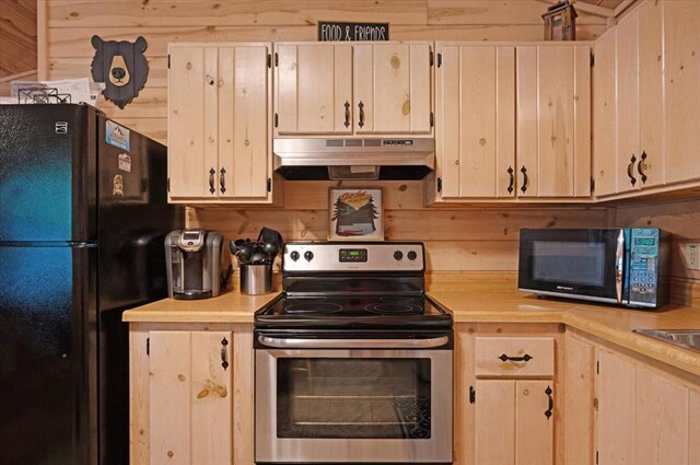 206 Orca Rd, Broken Bow, OK 74728 - kitchen featuring under cabinet range hood, black appliances, light countertops, and wood walls