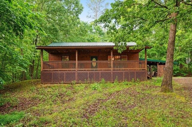 206 Orca Rd, Broken Bow, OK 74728 - view of front of house featuring faux log siding, metal roof, a porch, and a wooded view