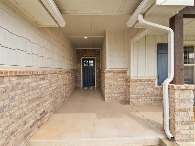 entrance to property with board and batten siding and brick siding