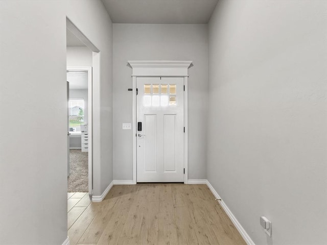 foyer entrance featuring baseboards and light wood finished floors