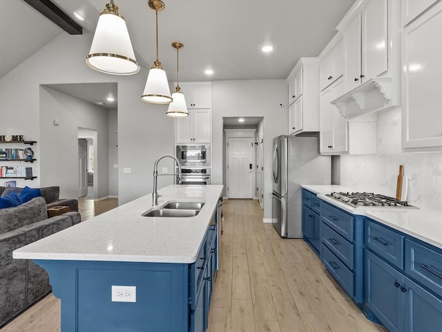 kitchen featuring a sink, stainless steel appliances, blue cabinets, light wood finished floors, and white cabinetry