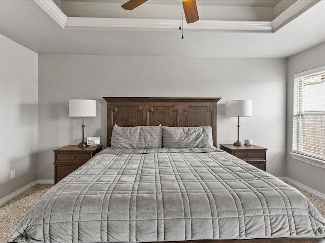 bedroom with baseboards, carpet flooring, a tray ceiling, and a ceiling fan