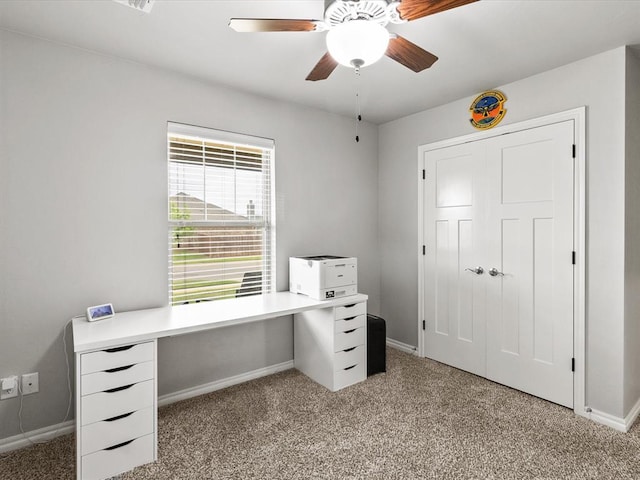 unfurnished office featuring baseboards, ceiling fan, and light colored carpet