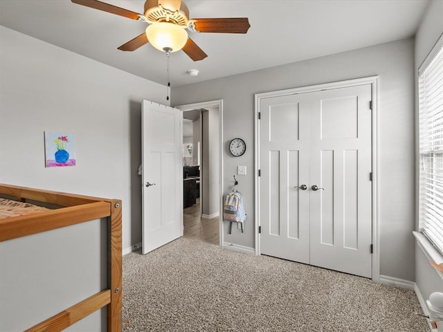 carpeted bedroom featuring baseboards, a closet, and a ceiling fan
