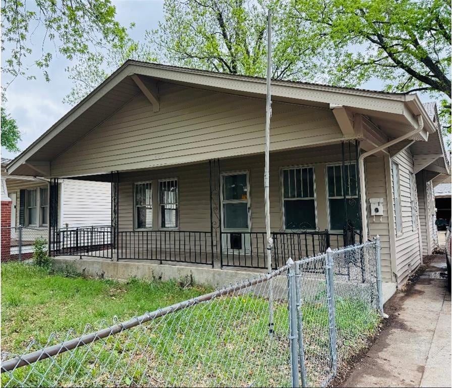 view of front of property featuring fence private yard and a porch