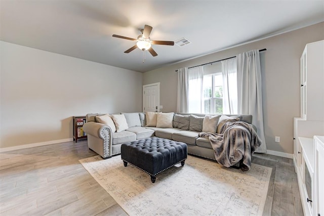 living area featuring baseboards, ceiling fan, visible vents, and wood finished floors