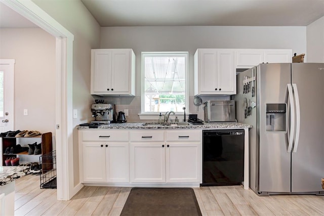 kitchen featuring white cabinetry, a sink, stainless steel fridge with ice dispenser, and dishwasher