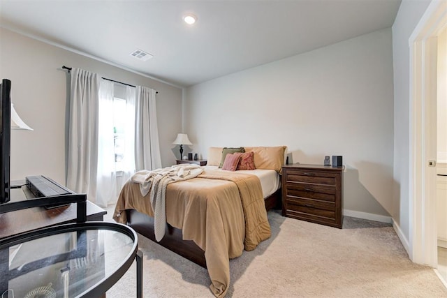 bedroom with baseboards, light colored carpet, and visible vents