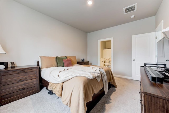 bedroom featuring visible vents, baseboards, ensuite bath, and light carpet