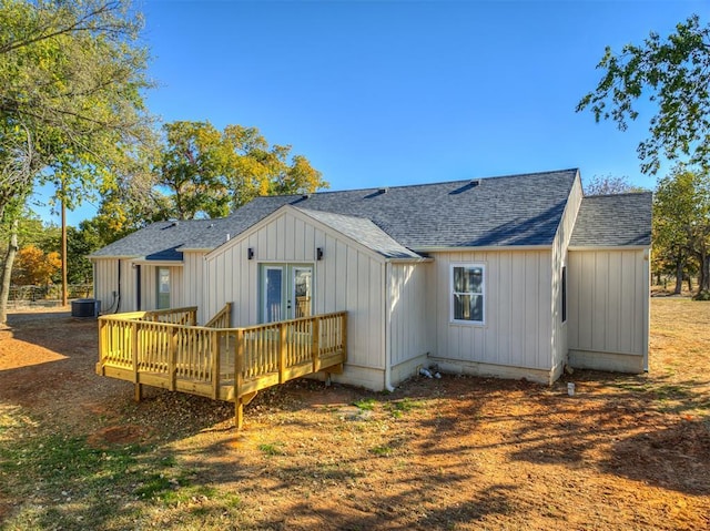 back of property featuring roof with shingles, a deck, and cooling unit