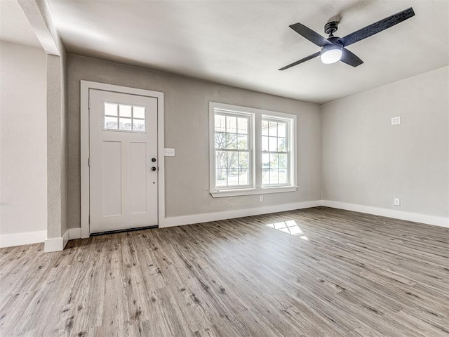 foyer entrance with baseboards, ceiling fan, and light wood-style flooring
