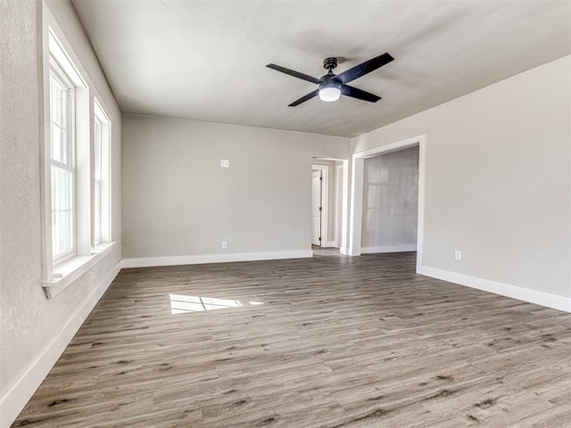 unfurnished room featuring baseboards, ceiling fan, and wood finished floors