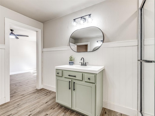bathroom featuring an enclosed shower, a wainscoted wall, vanity, and wood finished floors