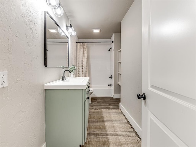 bathroom with vanity, a textured wall, and shower / tub combo