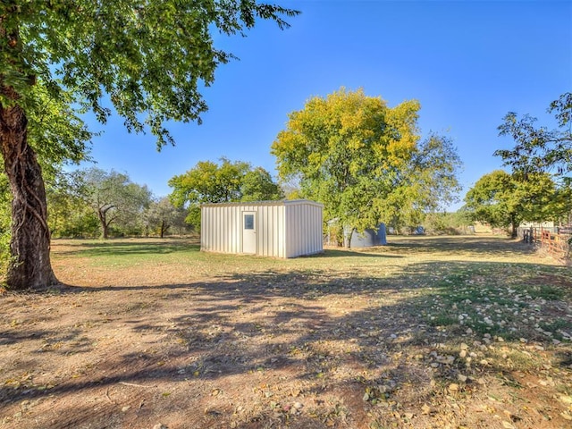 view of yard featuring a storage shed and an outbuilding
