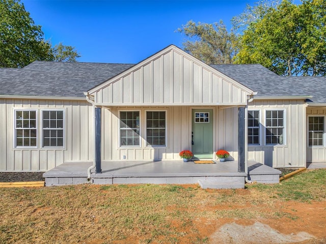 exterior space featuring a porch, board and batten siding, and roof with shingles