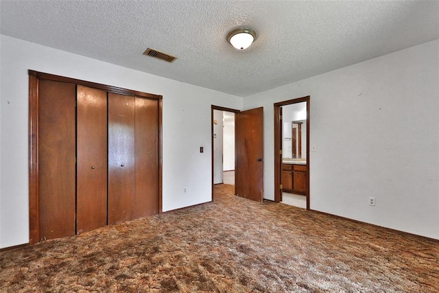 208 Harrogate Dr, Yukon, OK 73099 - unfurnished bedroom featuring carpet, a closet, a textured ceiling, and ensuite bathroom