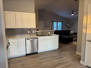 kitchen with white cabinets, light countertops, open floor plan, lofted ceiling, and stainless steel dishwasher