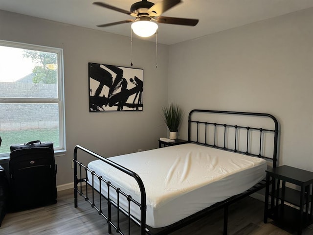 bedroom featuring baseboards, ceiling fan, and wood finished floors