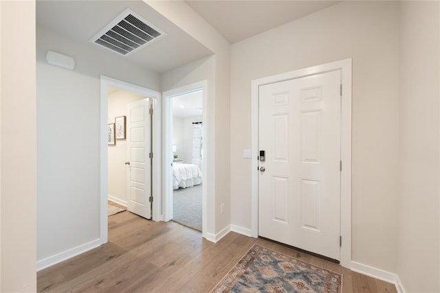 foyer with visible vents, baseboards, and light wood-type flooring