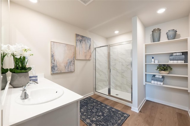 bathroom featuring visible vents, a shower stall, wood finished floors, baseboards, and recessed lighting
