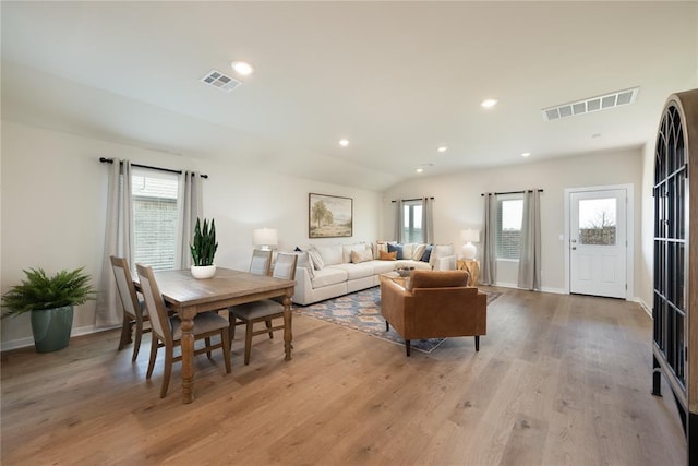 living room featuring plenty of natural light, light wood-type flooring, and visible vents