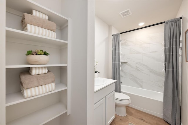 full bathroom with visible vents, wood finished floors, shower / tub combo, vanity, and toilet