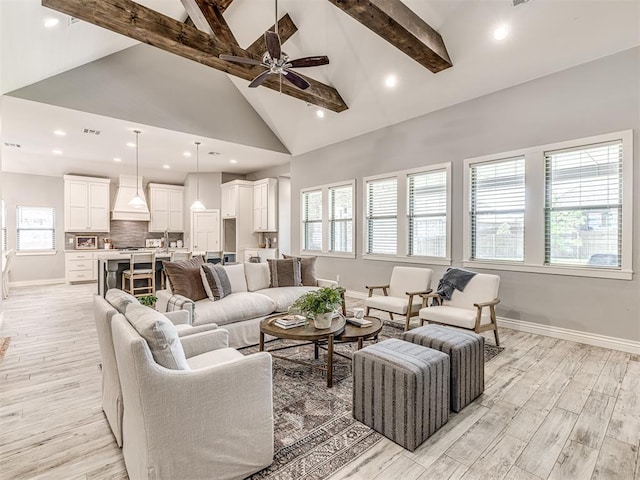 living area with high vaulted ceiling, baseboards, and beam ceiling