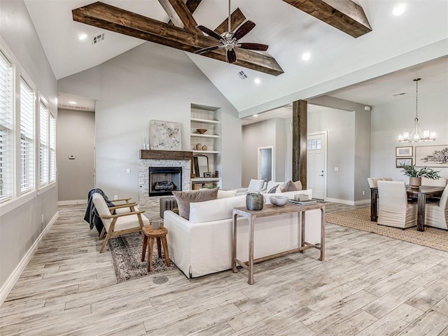 living room with baseboards, light wood-style flooring, ceiling fan with notable chandelier, and visible vents