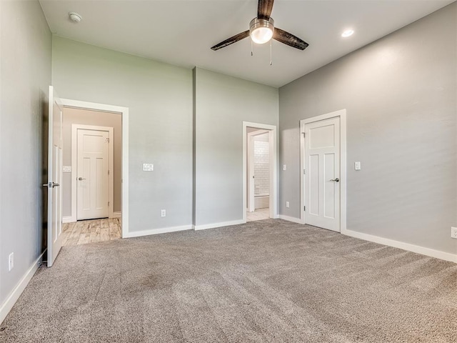 unfurnished bedroom with baseboards, carpet, ceiling fan, and ensuite bath