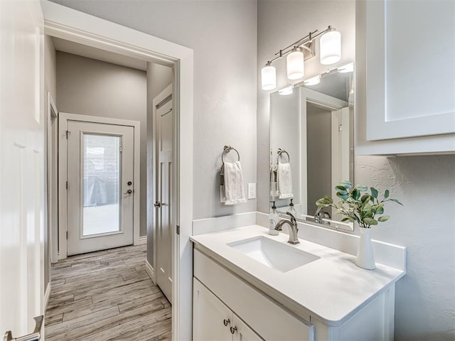 bathroom with a textured wall, wood finished floors, and vanity