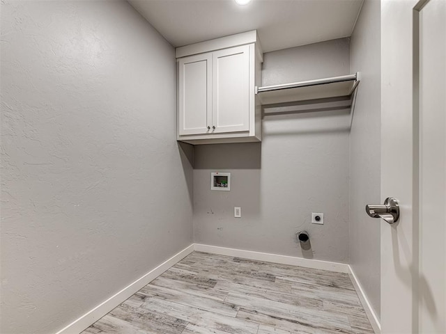 clothes washing area featuring hookup for an electric dryer, light wood-type flooring, cabinet space, baseboards, and hookup for a washing machine
