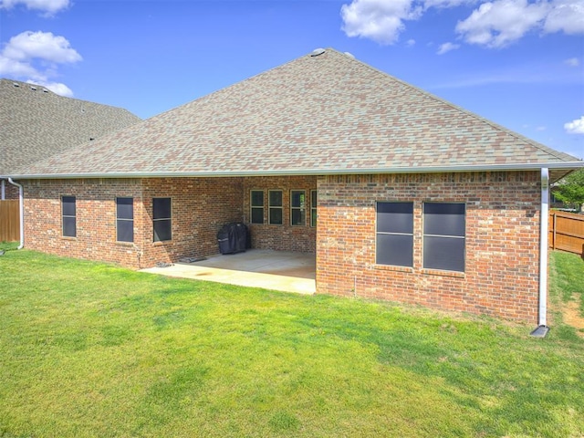 rear view of property featuring fence, a shingled roof, and brick siding