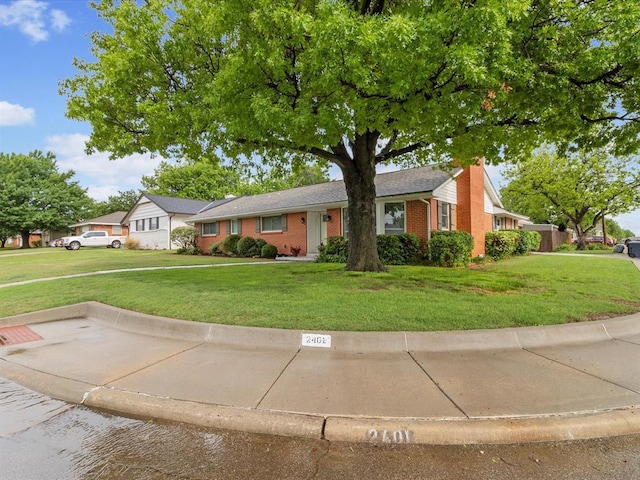 ranch-style house featuring a front lawn and brick siding