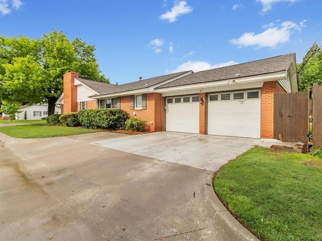 ranch-style home featuring brick siding, driveway, a front lawn, and a garage