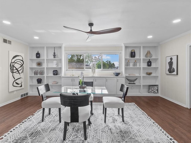 dining space featuring dark wood finished floors, built in features, a ceiling fan, visible vents, and ornamental molding