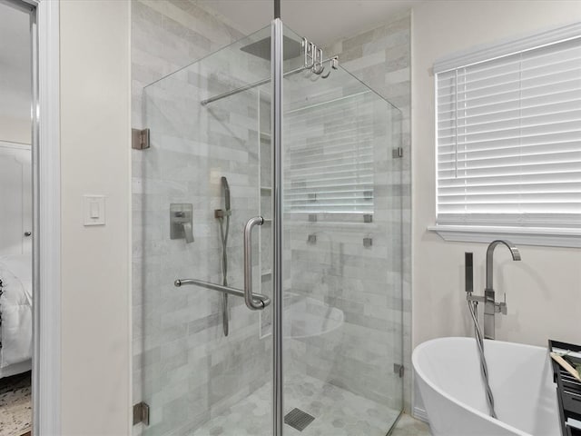 bathroom with a soaking tub and a shower stall