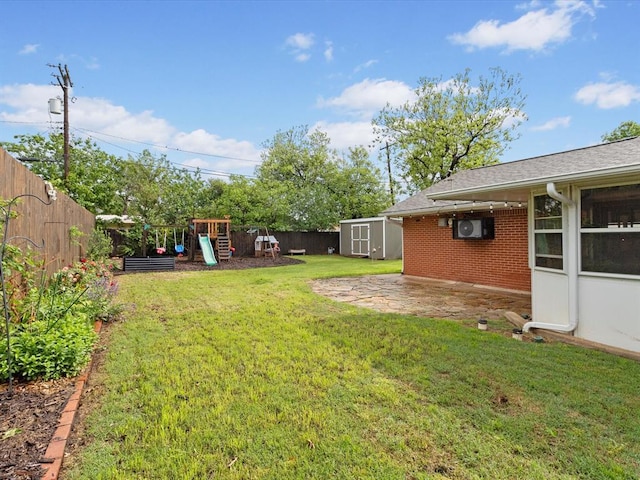 view of yard featuring a storage shed, an outdoor structure, a fenced backyard, and a playground