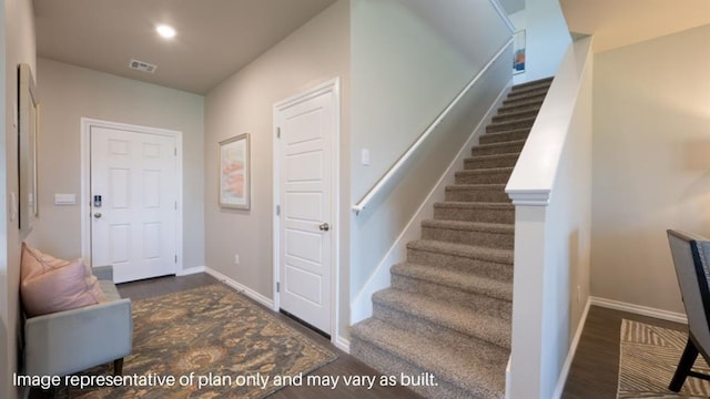 stairs with visible vents, baseboards, and wood finished floors