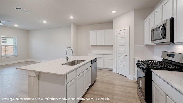 kitchen featuring visible vents, light stone countertops, light wood-style floors, a sink, and stainless steel appliances