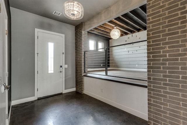 entryway with visible vents, baseboards, a notable chandelier, and finished concrete floors