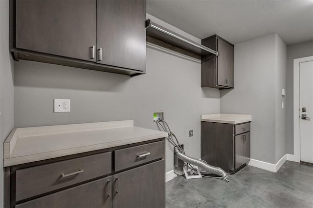 laundry room with cabinet space, baseboards, and washer hookup