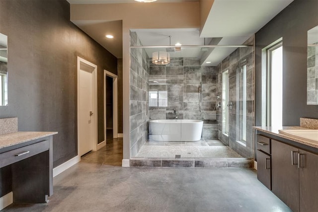 bathroom featuring finished concrete flooring, vanity, a stall shower, and a freestanding bath