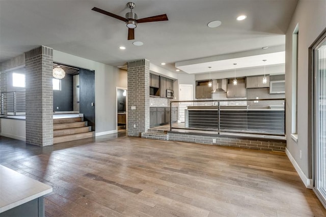 unfurnished living room featuring baseboards, a ceiling fan, wood-type flooring, and recessed lighting