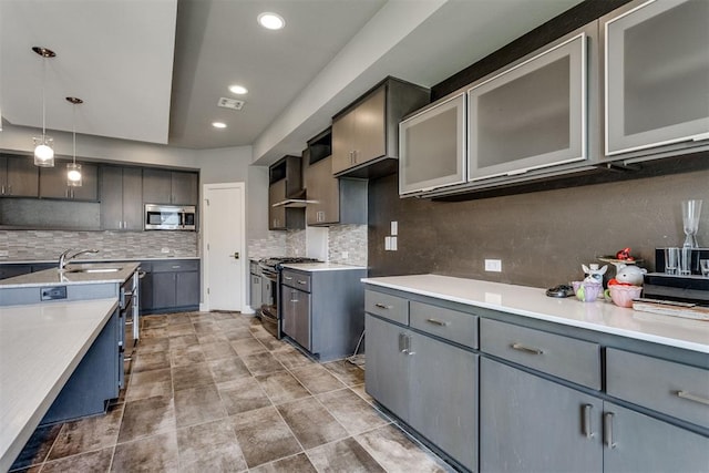 kitchen with stainless steel microwave, tasteful backsplash, a sink, and black range with gas stovetop