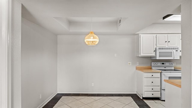 kitchen featuring tile patterned floors, white cabinets, baseboards, a raised ceiling, and white appliances