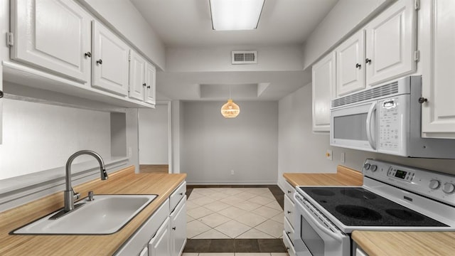 kitchen with visible vents, a sink, tile patterned floors, white appliances, and white cabinetry