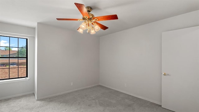 carpeted empty room featuring baseboards and ceiling fan
